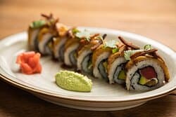 Caribbean Roll, filled with tuna tataki, cream cheese, avocado, and eel topped with sweet plantain, eel sauce, and crispy spam.