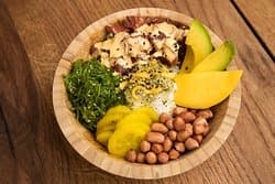 Our Traditional Tuna Poke is a diced tuna marinated in poke dressing and sesame seeds served with mango, avocado, pickled cucumbers, peanuts, wakame salad, and spicy mayonnaise.