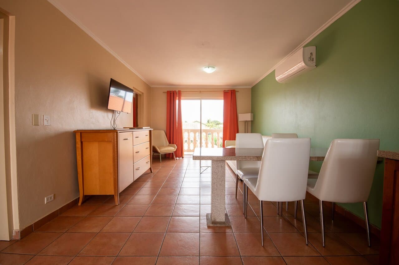 Spacious 2-bedroom apartment featuring a modern dining area, air conditioning, and a private balcony with relaxing outdoor views. The apartment offers a comfortable open layout with furnishings, perfect for families or small groups looking for a convenient and cozy stay.