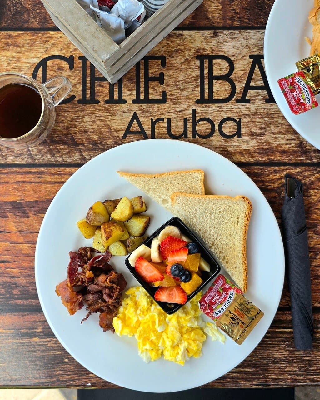 Big Breakfast. Scrambled eggs, crispy bacon, toast, and skilled potatoes. Served with a bowl of fresh fruit.