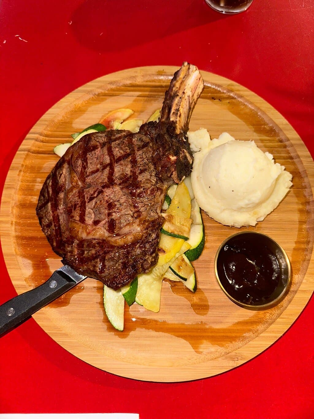 Cowboy Steak with side order of mashed potato and zuchini and yellow squash.